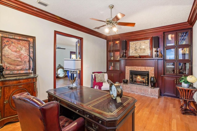 2828 Marquesas Ct, Windermere, FL 34786 - home office featuring a ceiling fan, ornamental molding, light wood finished floors, a brick fireplace, and a textured ceiling