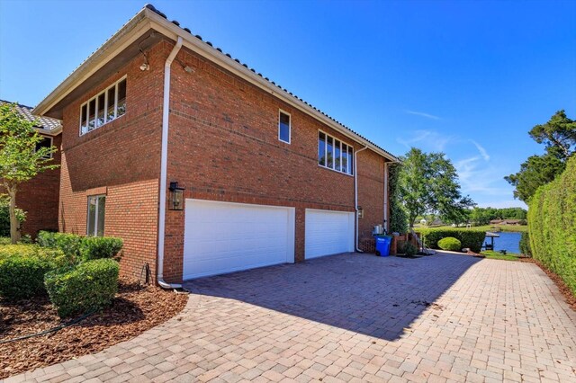 2828 Marquesas Ct, Windermere, FL 34786 - view of property exterior with a garage, brick siding, and driveway