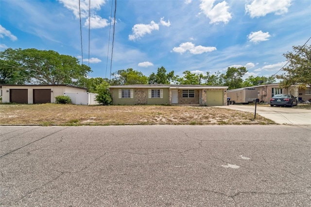 ranch-style house featuring fence and driveway
