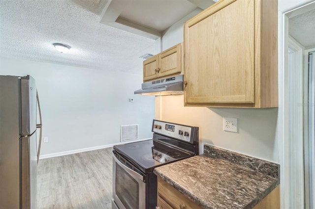 kitchen with light brown cabinetry, appliances with stainless steel finishes, under cabinet range hood, and a textured ceiling