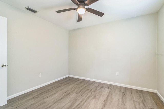 spare room with visible vents, baseboards, ceiling fan, and wood finished floors