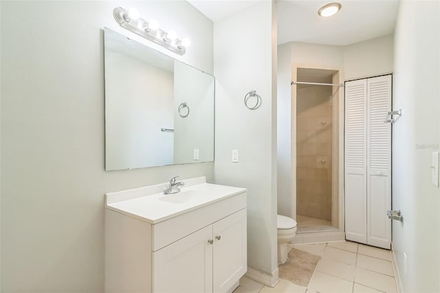 bathroom with vanity, toilet, tile patterned floors, a closet, and a stall shower