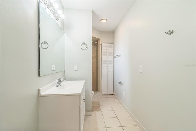 bathroom with tile patterned floors, baseboards, and vanity