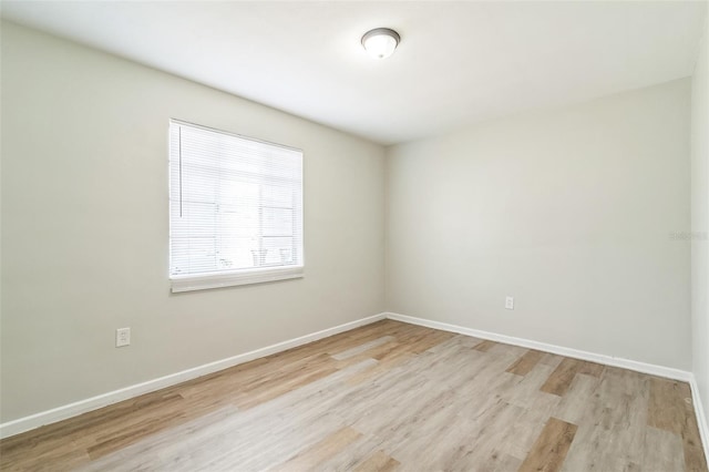unfurnished room featuring baseboards and light wood-type flooring