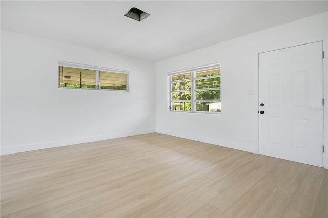 spare room featuring baseboards and light wood-type flooring