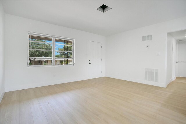 unfurnished room featuring visible vents, wood finished floors, and baseboards