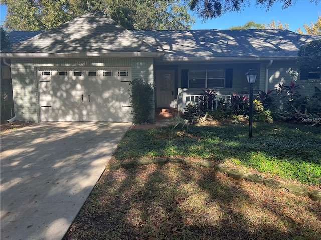 view of front facade featuring brick siding, a porch, concrete driveway, and an attached garage