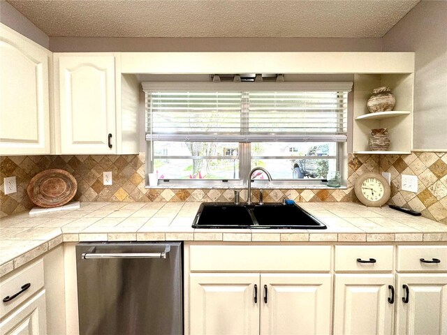 9490 SW 85th Ave Unit E, Ocala, FL 34481 - kitchen featuring dishwasher, a sink, healthy amount of natural light, tasteful backsplash, and a textured ceiling