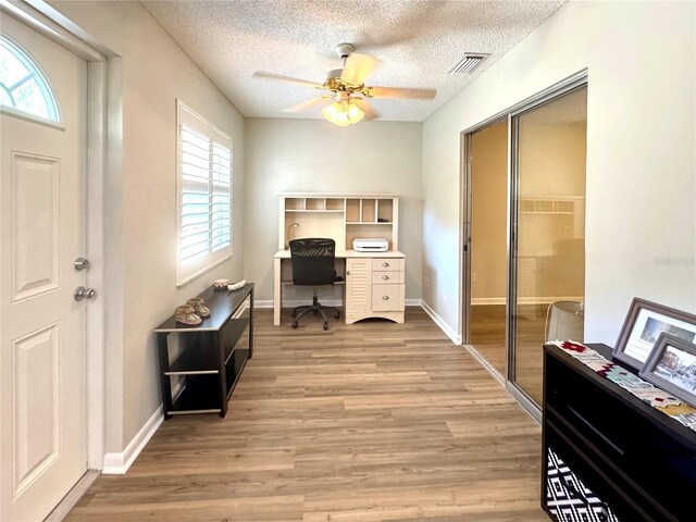 9490 SW 85th Ave Unit E, Ocala, FL 34481 - home office with light wood-type flooring, plenty of natural light, a ceiling fan, and a textured ceiling