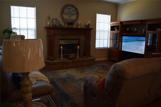 living area featuring ornamental molding and a brick fireplace