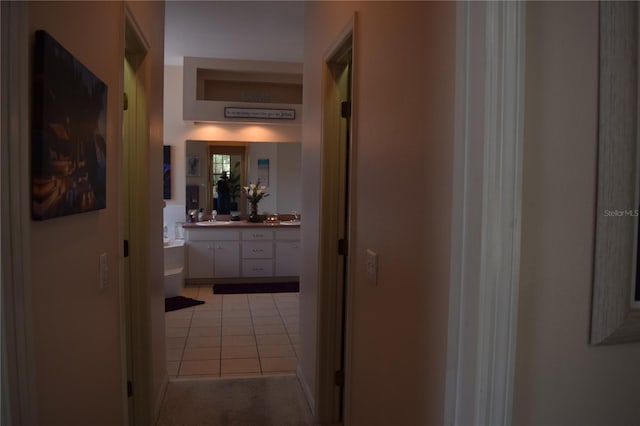 hallway featuring a sink and light tile patterned floors