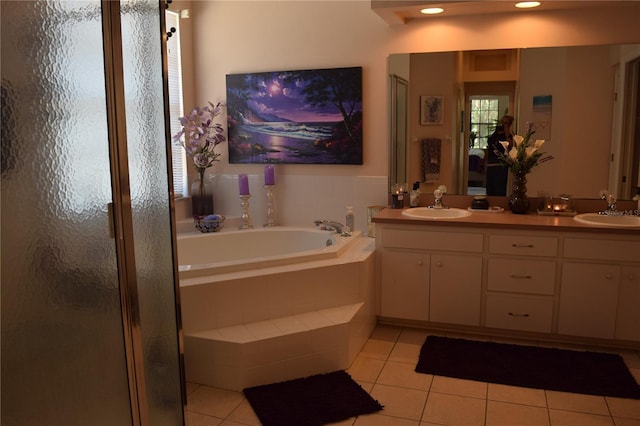 ensuite bathroom with a bath, a sink, tile patterned flooring, and a stall shower