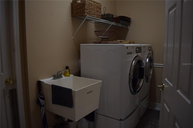 laundry room with laundry area, washing machine and dryer, and a sink