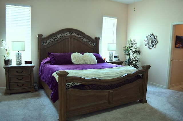 bedroom with baseboards and light carpet
