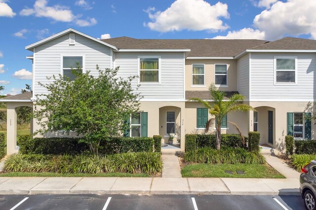320 Primrose Dr, Davenport, FL 33837 - townhome / multi-family property with uncovered parking, a shingled roof, and stucco siding