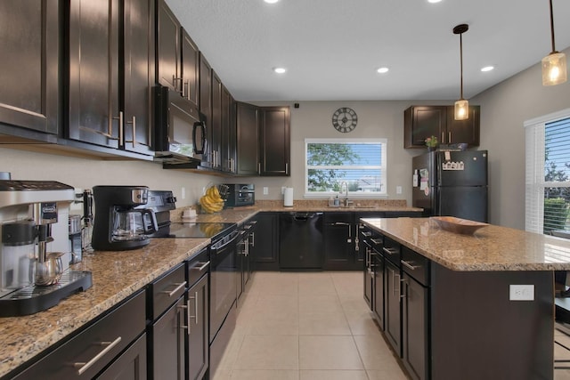 320 Primrose Dr, Davenport, FL 33837 - kitchen with black appliances, a sink, light stone countertops, a center island, and light tile patterned floors