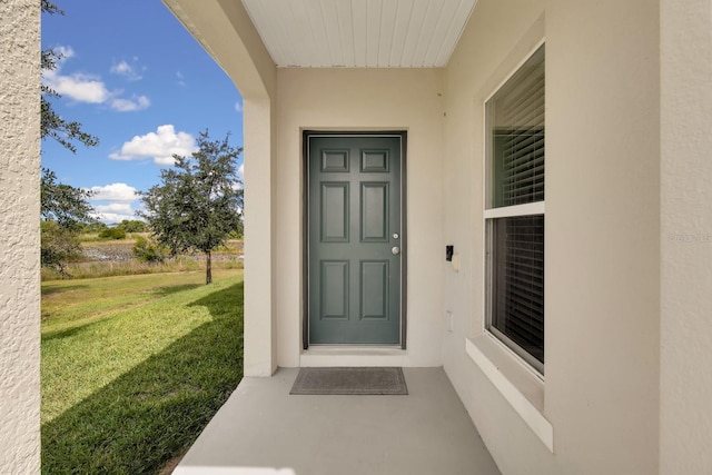 320 Primrose Dr, Davenport, FL 33837 - view of exterior entry featuring a yard and stucco siding