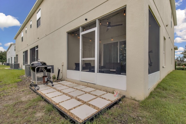 320 Primrose Dr, Davenport, FL 33837 - rear view of property with stucco siding, a sunroom, and central AC