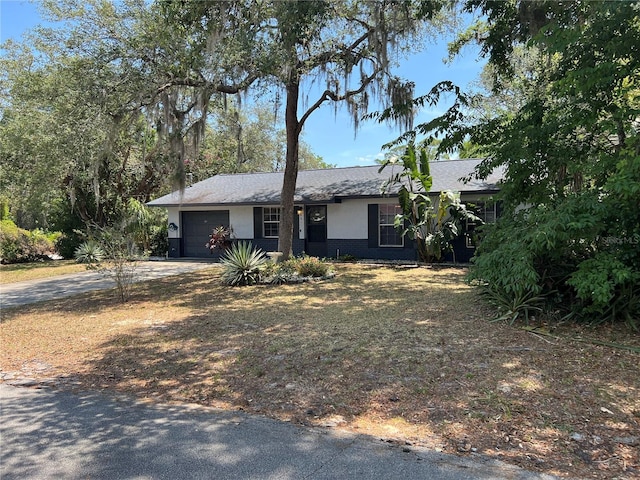 261 Deleon Rd, Debary, FL 32713 - view of front of property featuring driveway, an attached garage, and stucco siding