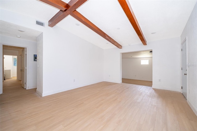unfurnished living room featuring light wood-style flooring, visible vents, beam ceiling, and a wealth of natural light