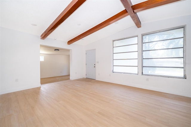 unfurnished living room with light wood-style floors, vaulted ceiling with beams, and baseboards