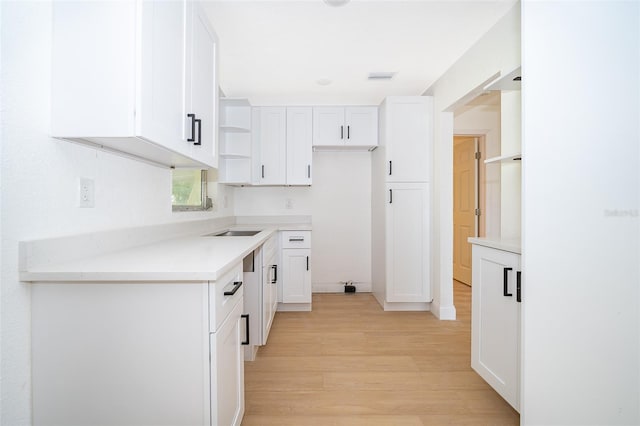 kitchen featuring open shelves, light wood-type flooring, visible vents, light countertops, and white cabinets