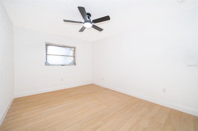 empty room with light wood-type flooring, a ceiling fan, and baseboards