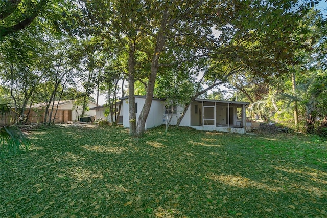 view of yard with fence and a sunroom