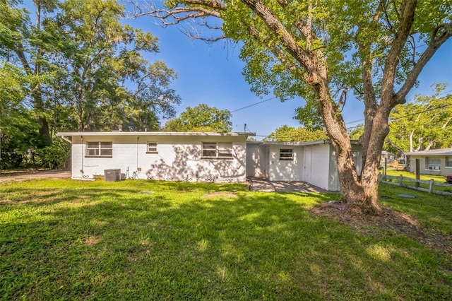 ranch-style house with cooling unit, a front yard, and fence