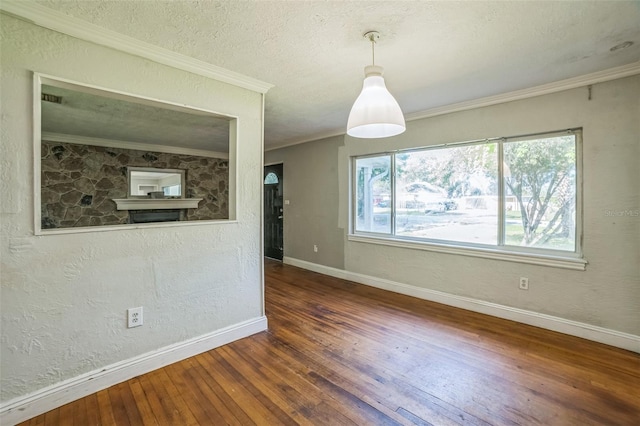 unfurnished dining area featuring crown molding, a textured wall, baseboards, a textured ceiling, and hardwood / wood-style flooring