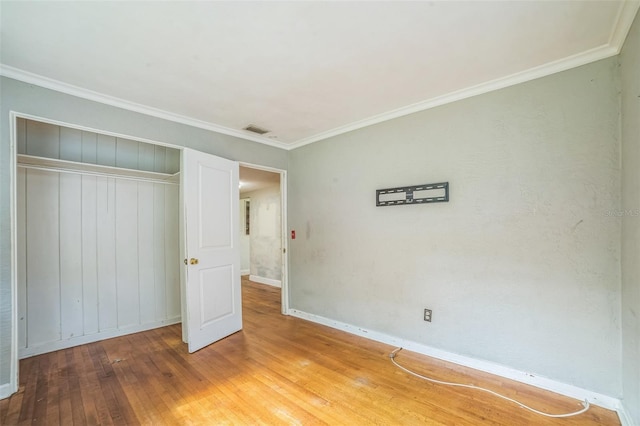 unfurnished bedroom with visible vents, light wood-style floors, a closet, baseboards, and ornamental molding