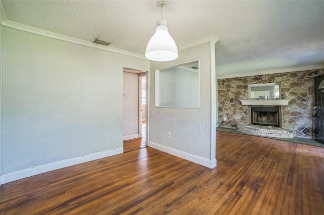 unfurnished living room featuring a textured ceiling, crown molding, baseboards, wood-type flooring, and a fireplace