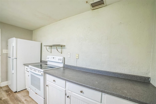 kitchen with light wood finished floors, visible vents, white cabinetry, white appliances, and dark countertops
