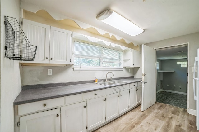 kitchen with white cabinets, open shelves, light wood-style floors, and a sink