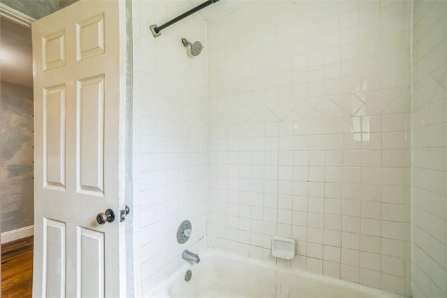 full bathroom featuring wood finished floors, shower / washtub combination, and baseboards