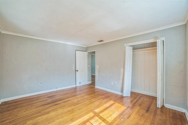 unfurnished bedroom featuring baseboards, visible vents, light wood-type flooring, and a closet