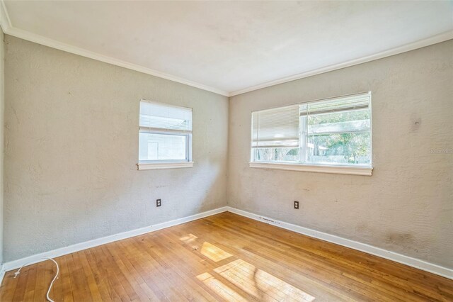 unfurnished room with plenty of natural light, baseboards, and light wood-type flooring