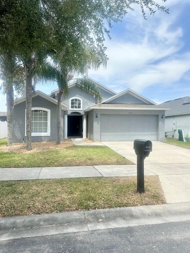 ranch-style home with stucco siding, an attached garage, driveway, and a front yard
