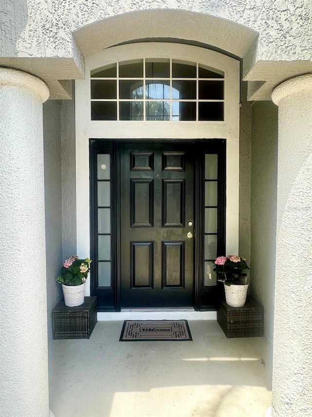 entrance to property featuring stucco siding