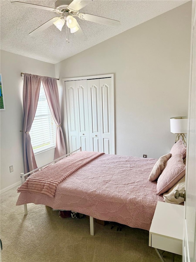 bedroom featuring a closet, carpet flooring, a textured ceiling, and ceiling fan