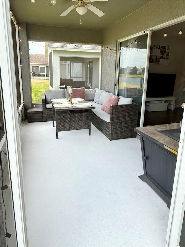sunroom featuring an outdoor living space and a ceiling fan