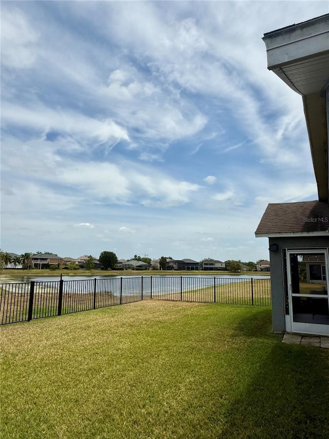 view of yard featuring a fenced backyard and a water view