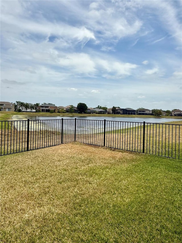 view of yard featuring a water view and fence