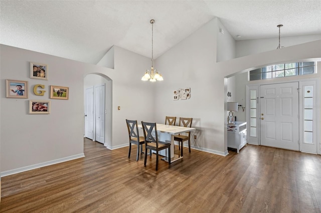 2407 Oakington St, Winter Garden, FL 34787 - dining area featuring arched walkways, a chandelier, high vaulted ceiling, wood finished floors, and baseboards