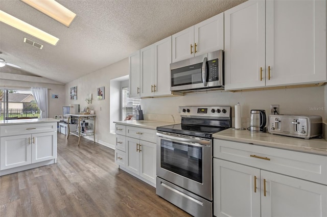 2407 Oakington St, Winter Garden, FL 34787 - kitchen featuring appliances with stainless steel finishes, healthy amount of natural light, a textured ceiling, light countertops, and white cabinets
