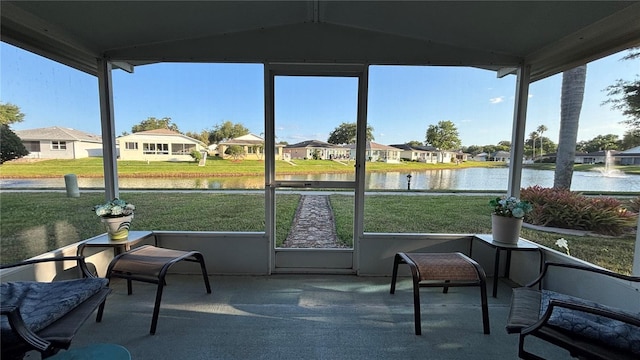 sunroom featuring a water view and a residential view