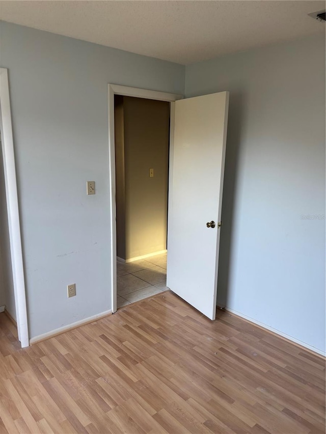 unfurnished bedroom featuring visible vents and light wood-style flooring