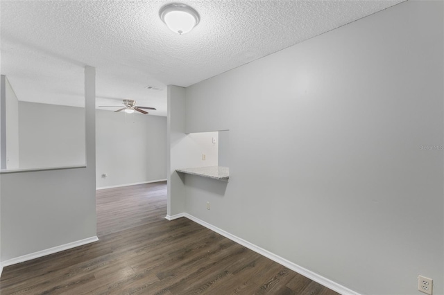 unfurnished room with visible vents, dark wood-style flooring, baseboards, a textured ceiling, and a ceiling fan