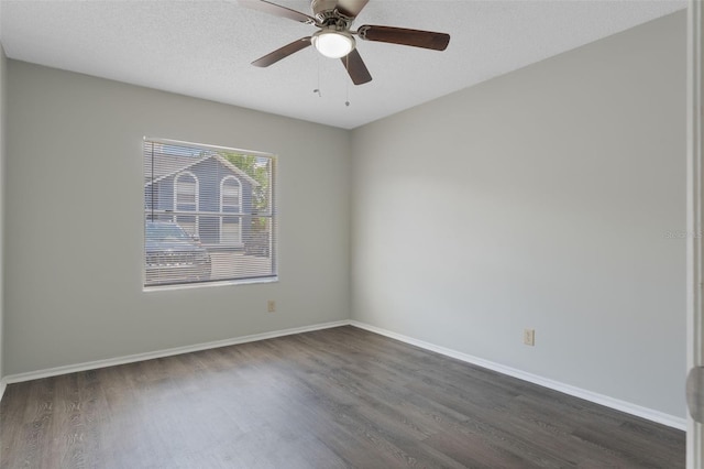 spare room featuring a ceiling fan, baseboards, and dark wood finished floors