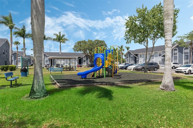 communal playground featuring a lawn and a residential view